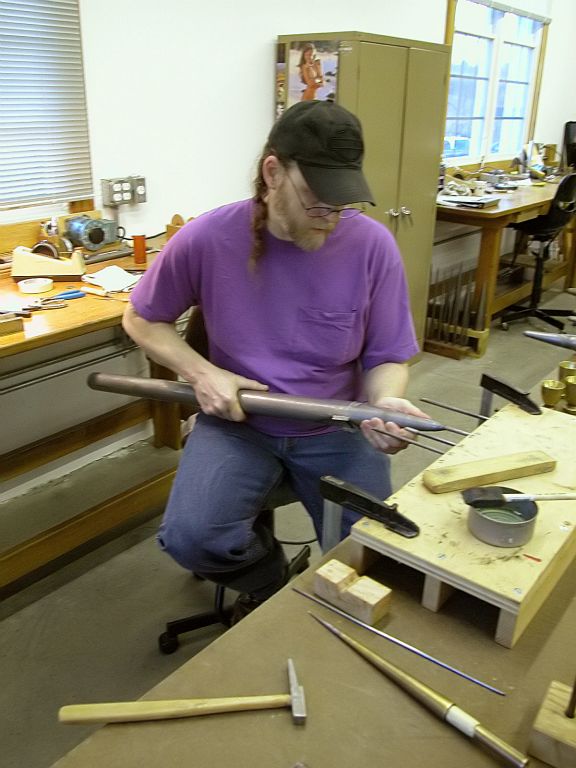 Jeff Peterson removing dents from the feet of the pipes.